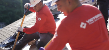 Two men working on a roof